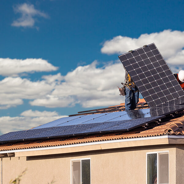 a man working on a solar panel on the roof of a house