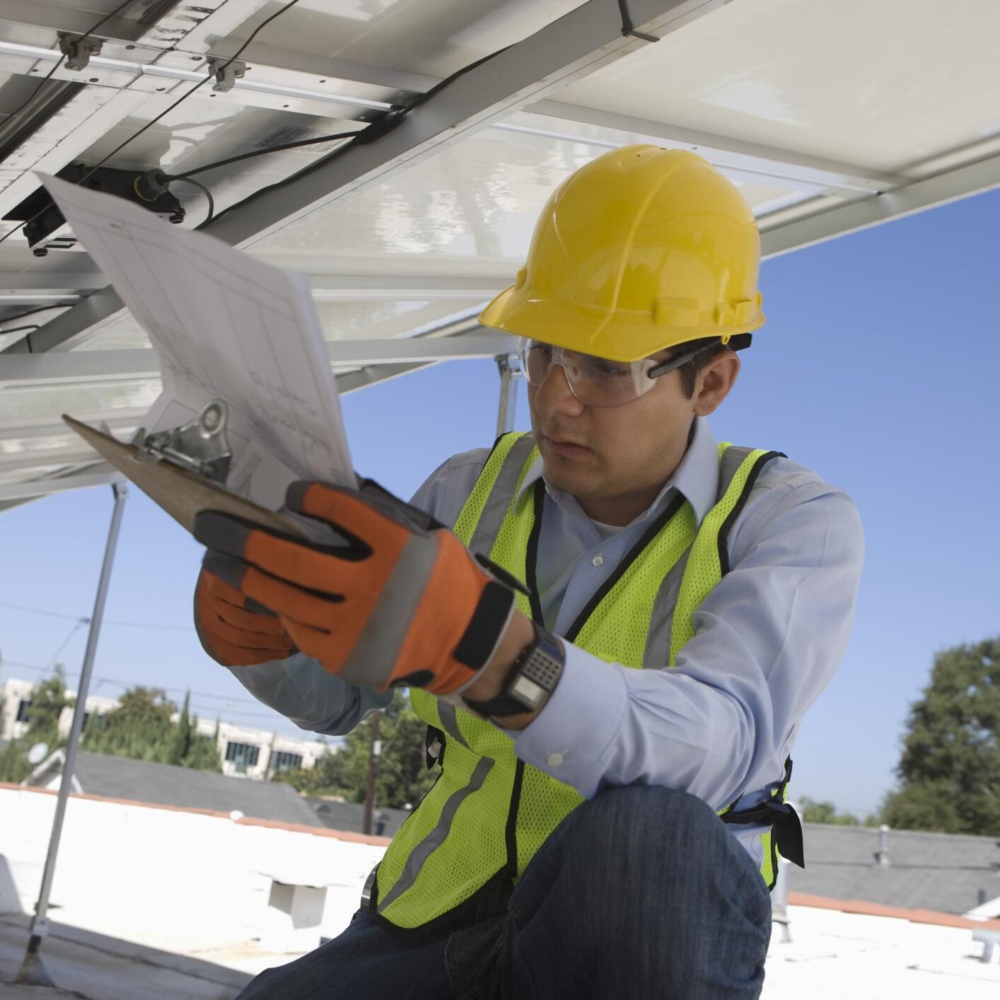 a man in a hard hat and safety vest holding a piece of paper