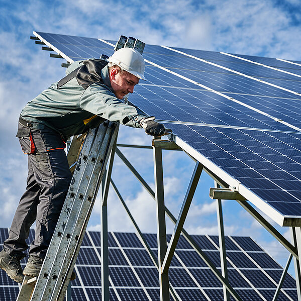 a man on a ladder working on a solar panel