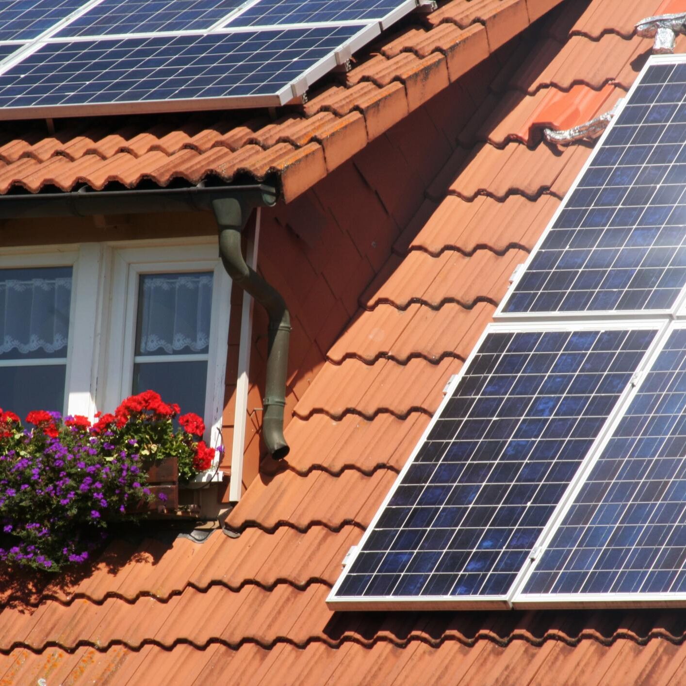 a red roof with a window and a solar panel on it